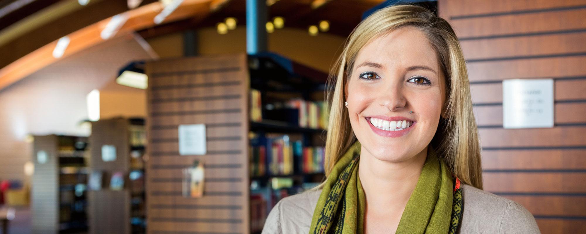 Woman standing in library smiling