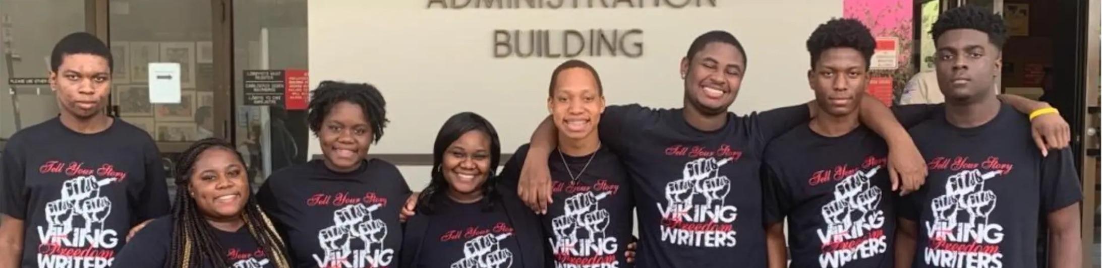 Dr. Symonette posing with several students all wearing shirts that say Viking Freedom Writers