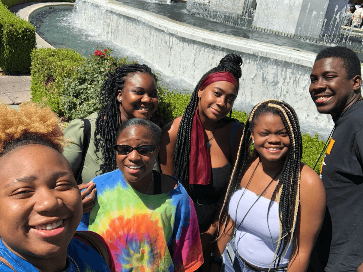Several high school students taking a selfie near a water fountain; all smiling